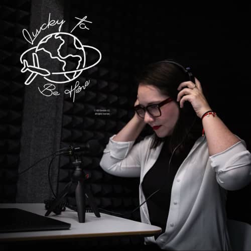 Host Dr. Analía Gómez Vidal, C.P.C. in a recording studio, putting her headset on while sitting in front of a mic and laptop.