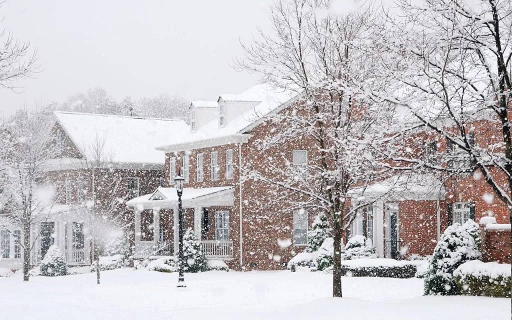 Winter storm hitting a neighborhood of traditional brick homes