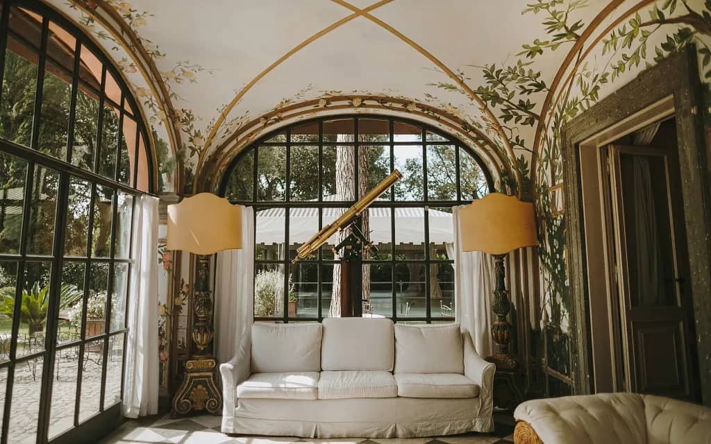 Veranda of renaissance styled home with ceiling mural and vintage furniture