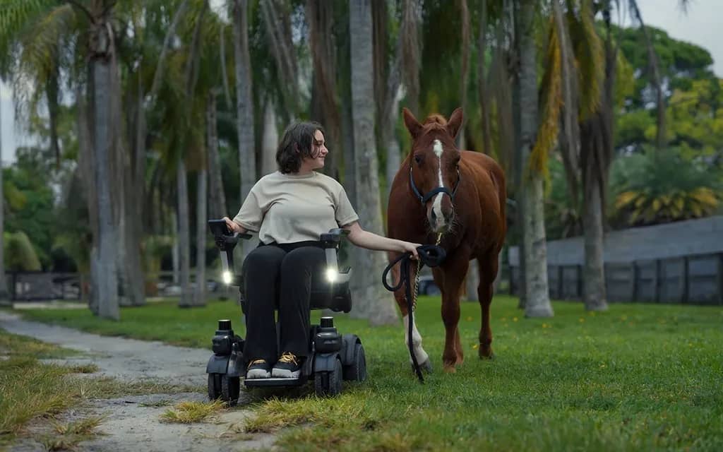 The Strutt EV1 personal mobility vehicle being used to walk a horse along a trail