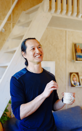 Photo of Trent smiling while holding a mug