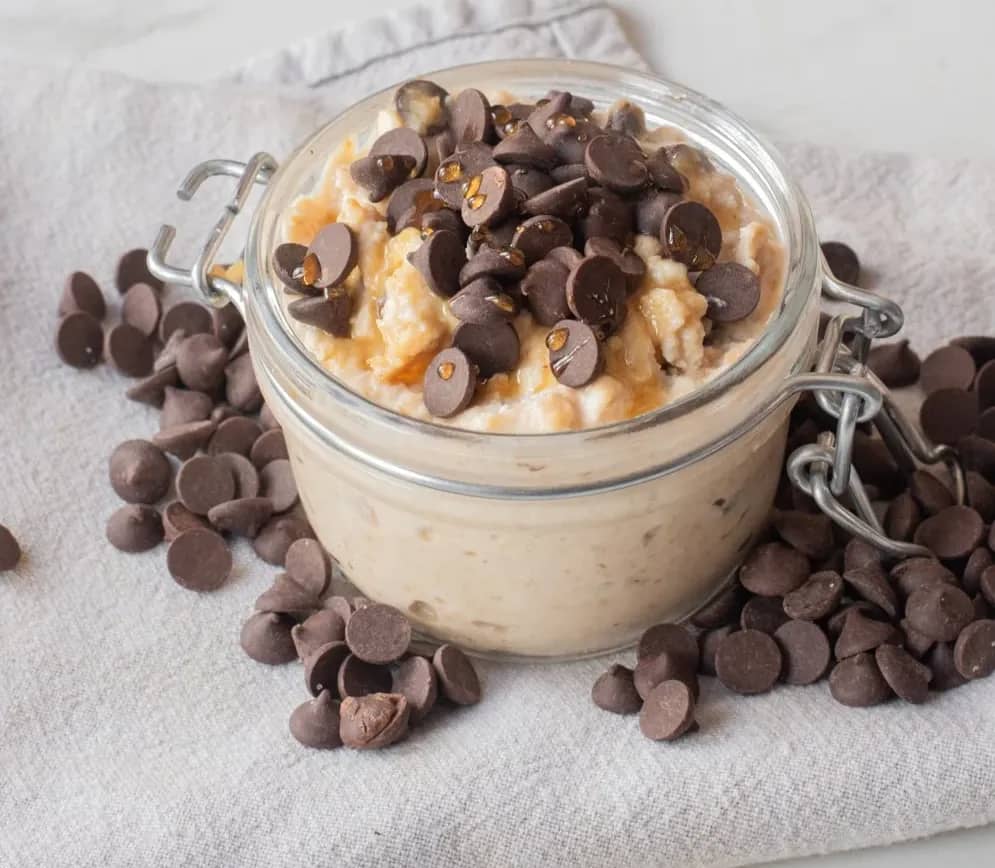 Close-up of cottage cheese cookie dough overnight oats topped with mini chocolate chips in a jar.
