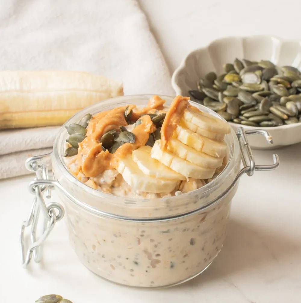 A close up image of peanut butter banana overnight oats in a mason jar.