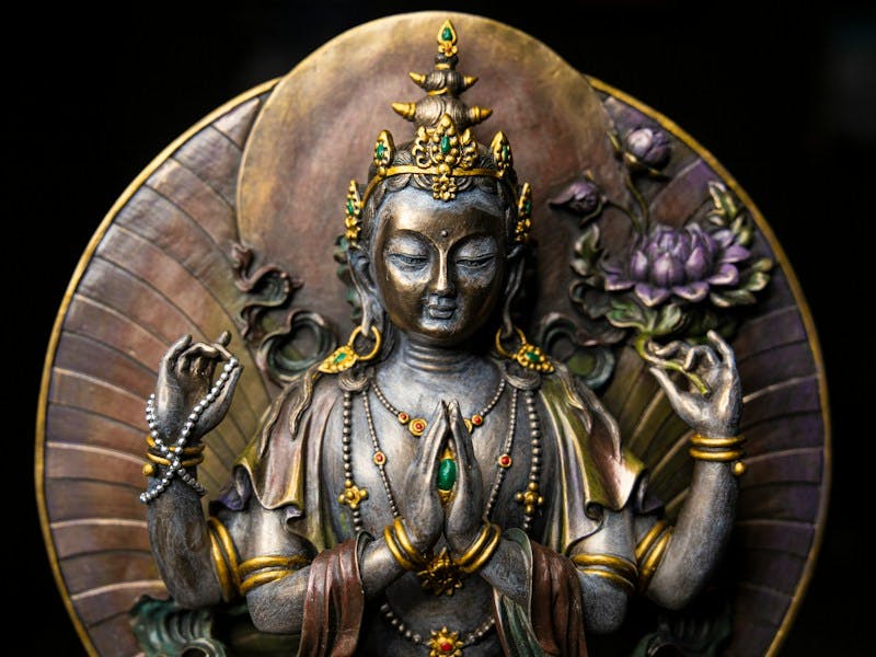 gold hindu deity statue with black background