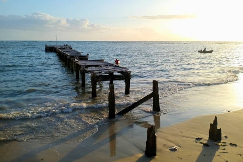 A dilapidated pier stretches into the ocean.