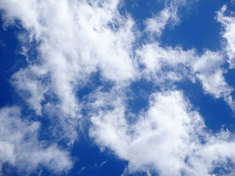 Blue sky with scattered white fluffy clouds.