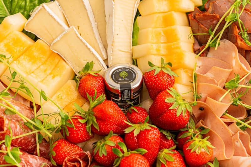 A delicious charcuterie board with fresh fruits.