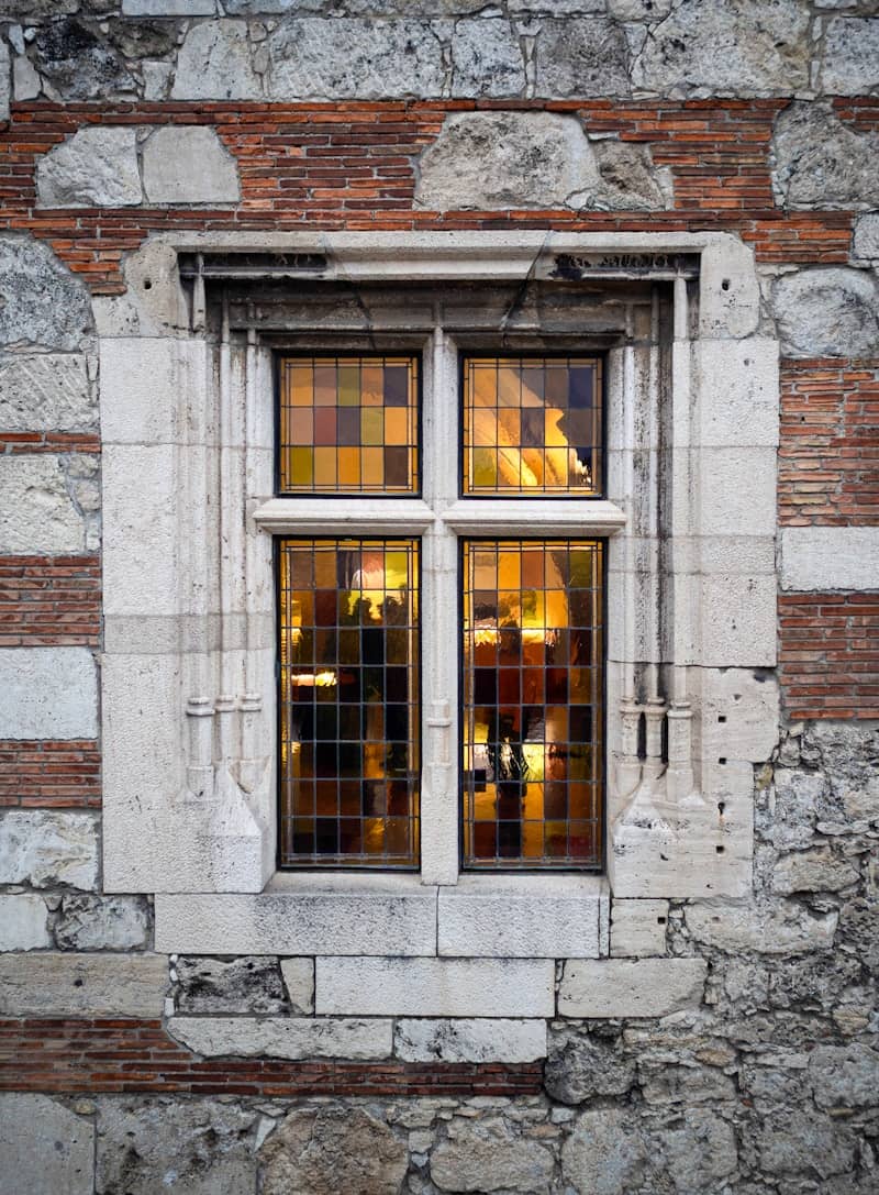 Colorful glass window in an ancient stone and brick building.