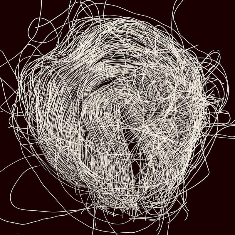 A tangled ball of white thread on a dark background.