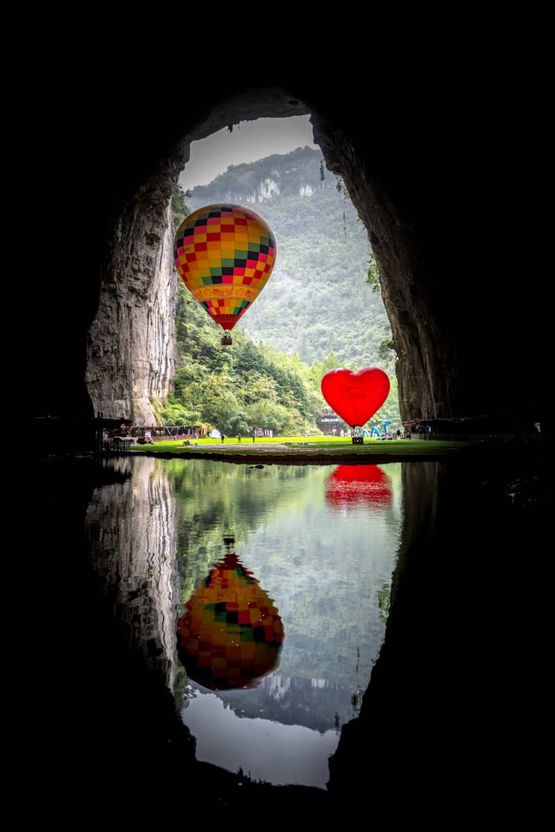 Hot air balloons and heart shape reflected in water