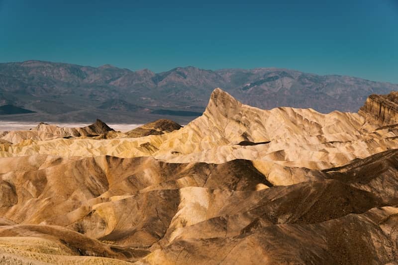 Arid desert landscape with dramatic rock formations under clear sky