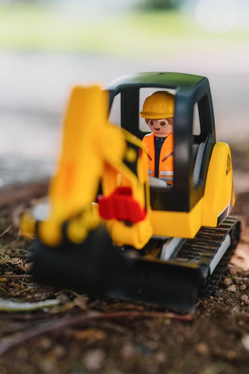 A toy excavator is sitting on the ground