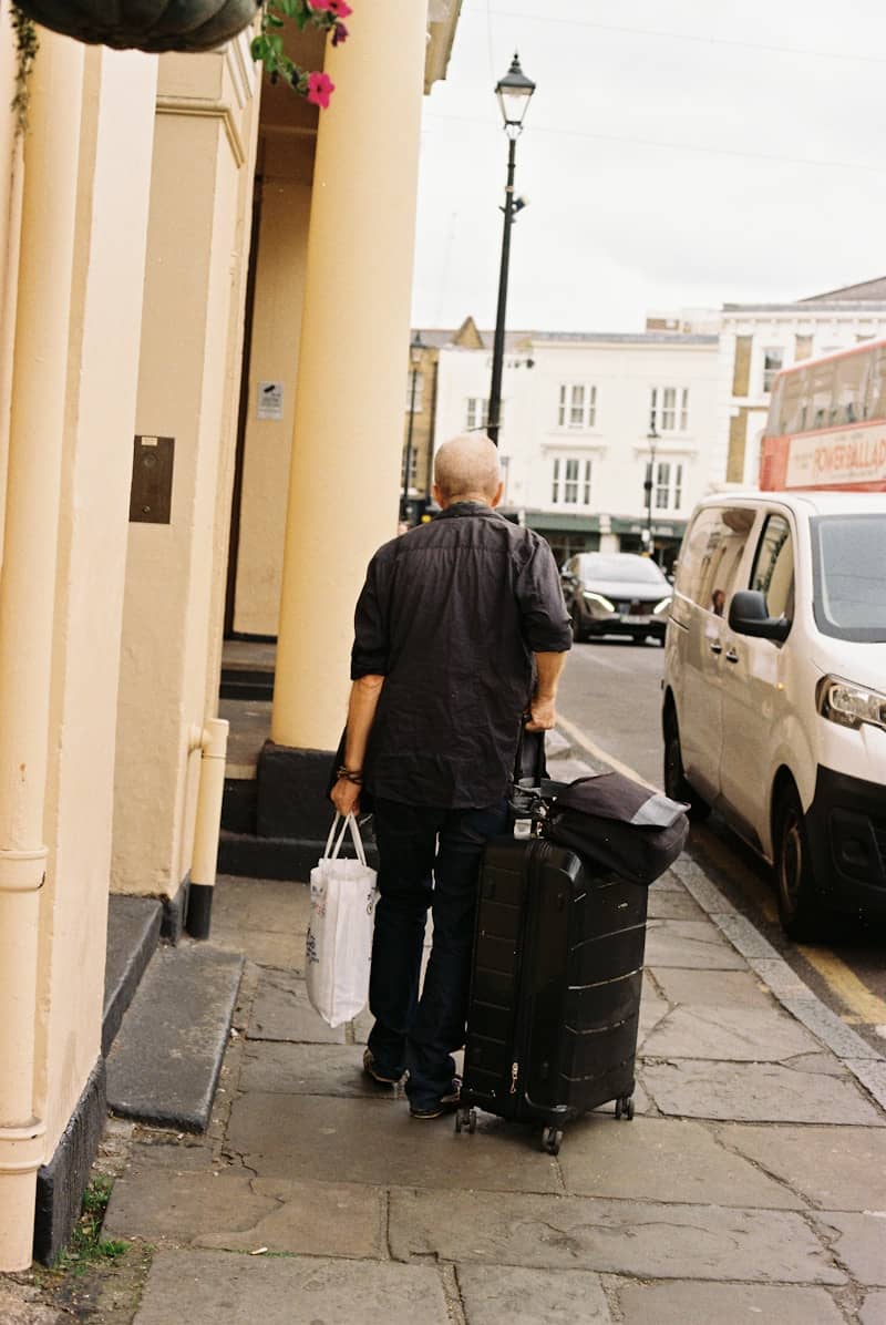 a man carrying heavy bags in a city