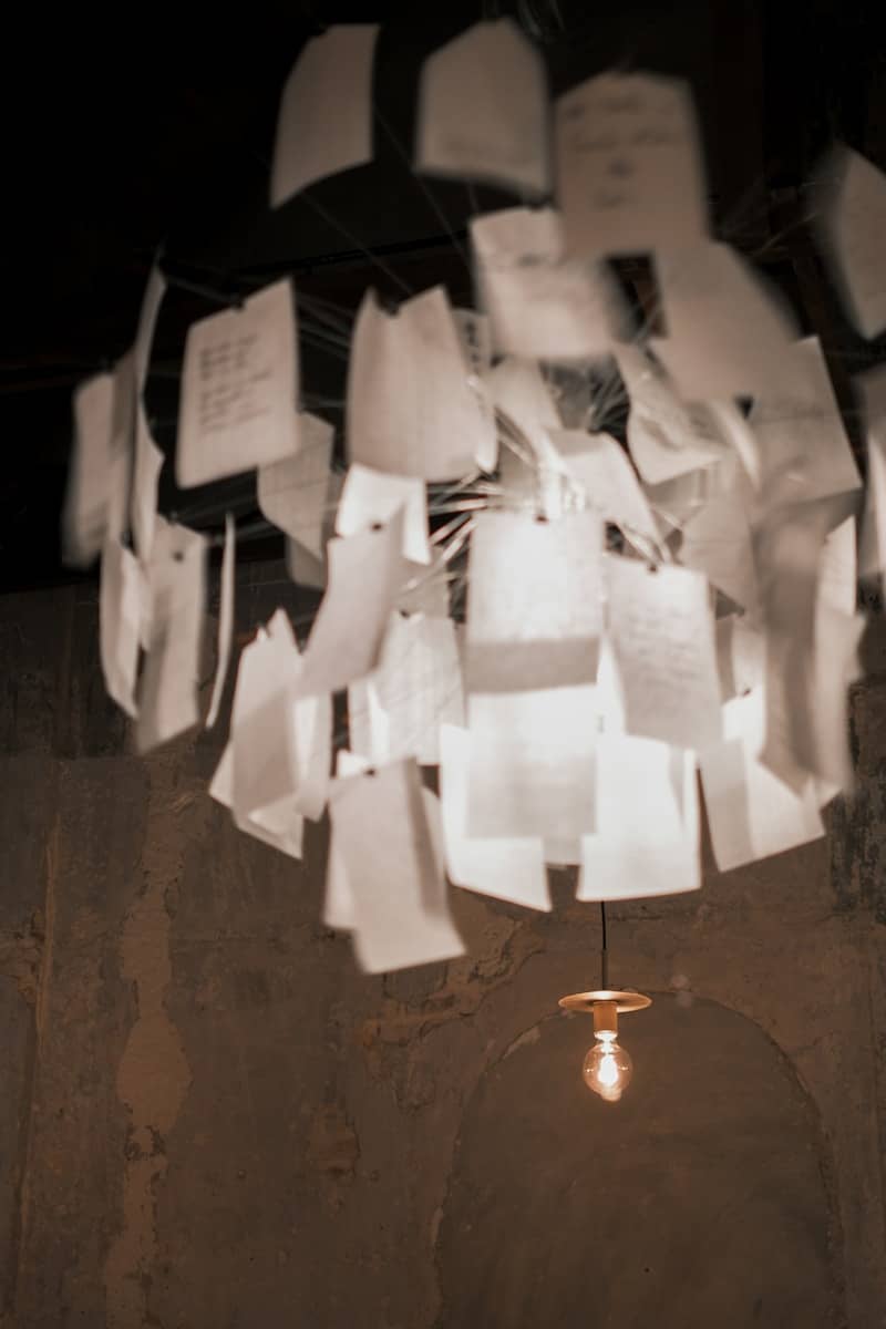 Chandelier made of hanging papers with a single bulb.