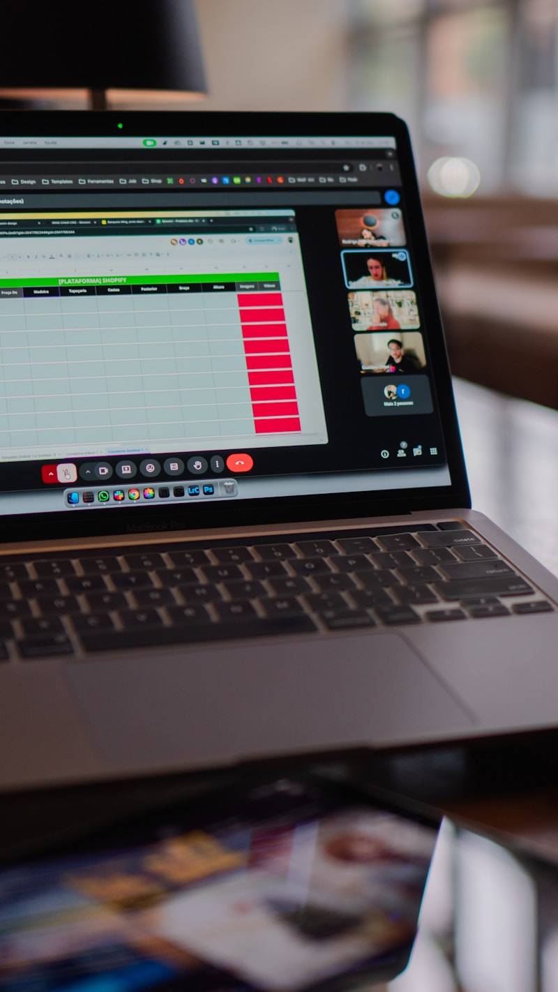 Laptop screen showing a video conference and spreadsheet.