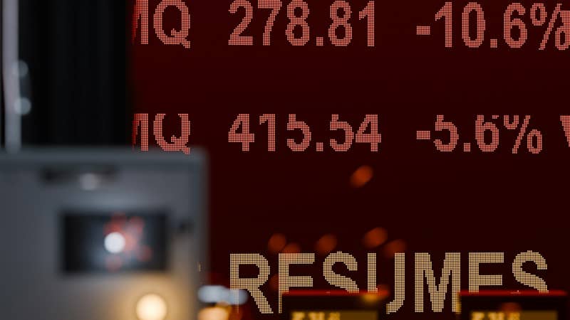 Red digital stock market ticker display with numbers and the word RESUMES