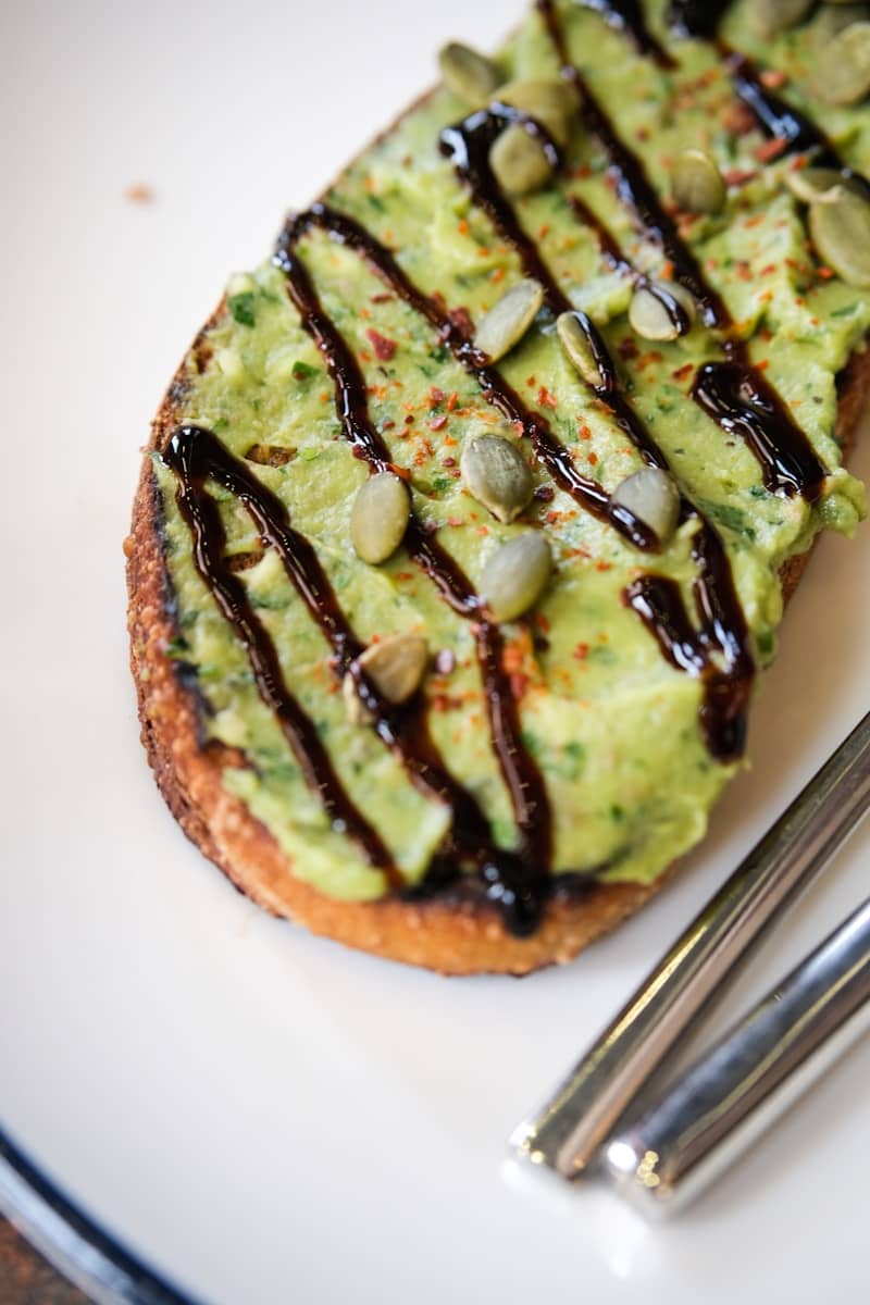 Avocado toast with pumpkin seeds and balsamic glaze.