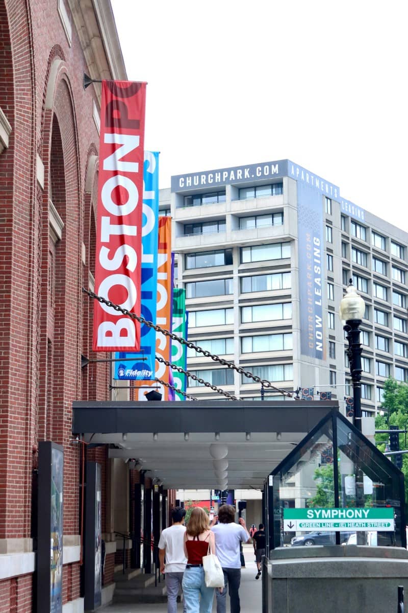 People walk under colorful 'boston' banners in a city