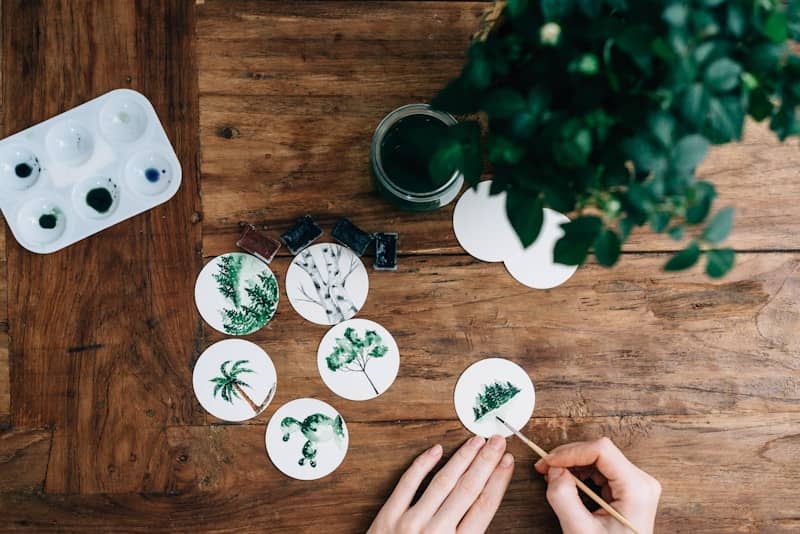 person painting green leafed plant