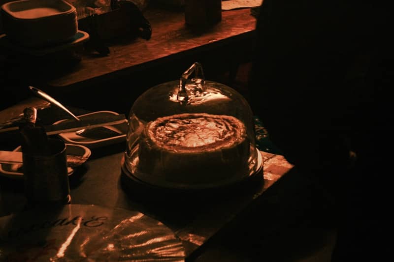 A pie covered by a glass dome on a table