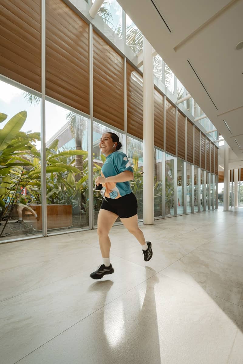 A woman runs down a bright, modern hallway.