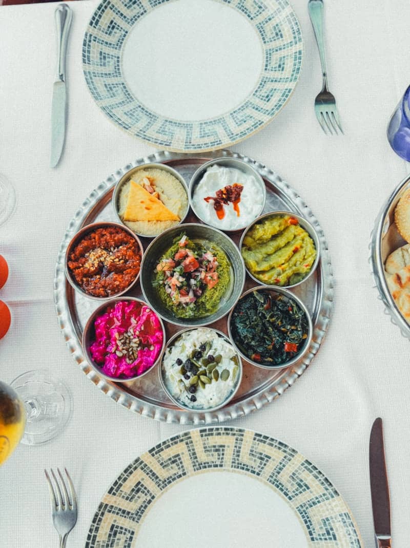 Assortment of colorful dips served on a round silver tray
