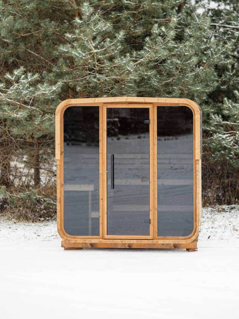 Modern wooden sauna cabin in a snowy forest