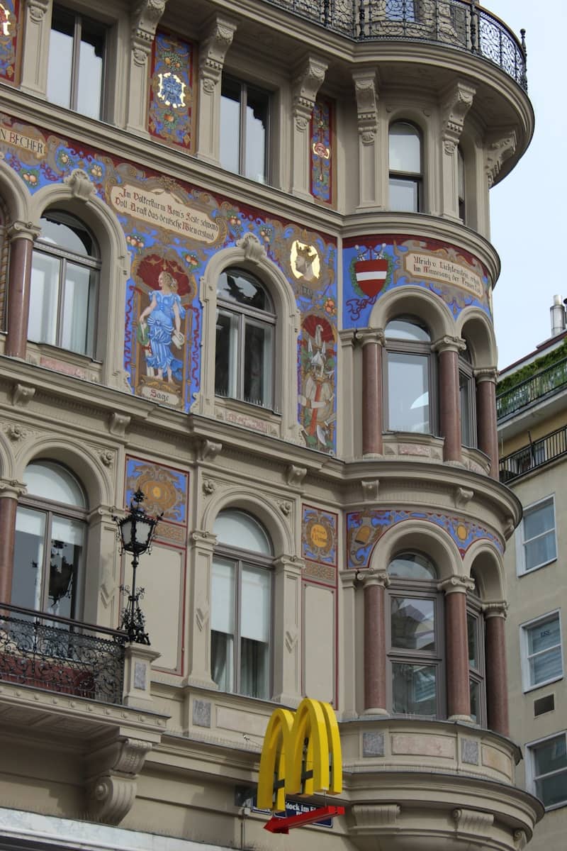 Historic building with colorful murals and a mcdonald's sign.