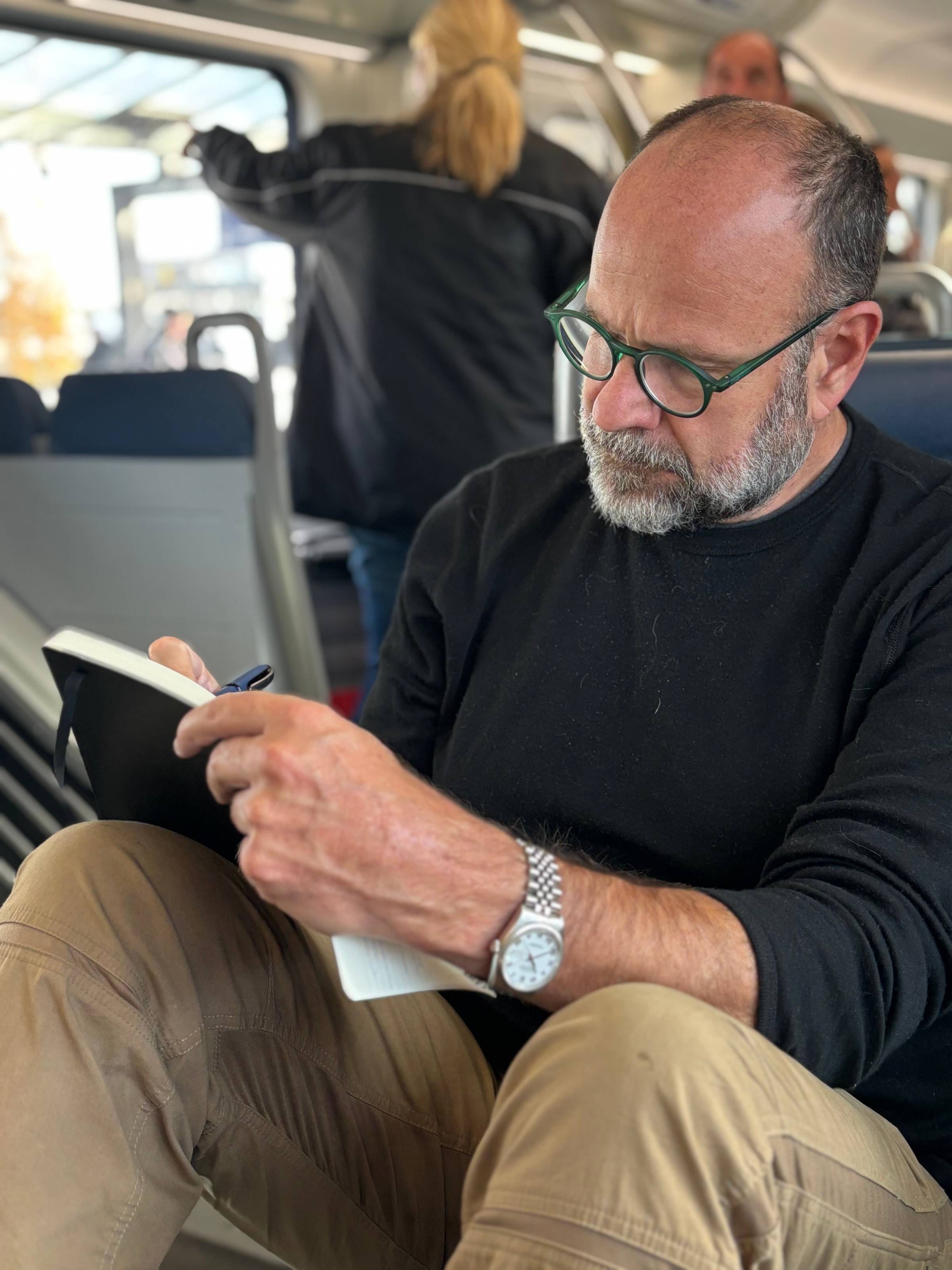 Andrew Bridgeman writing on a train