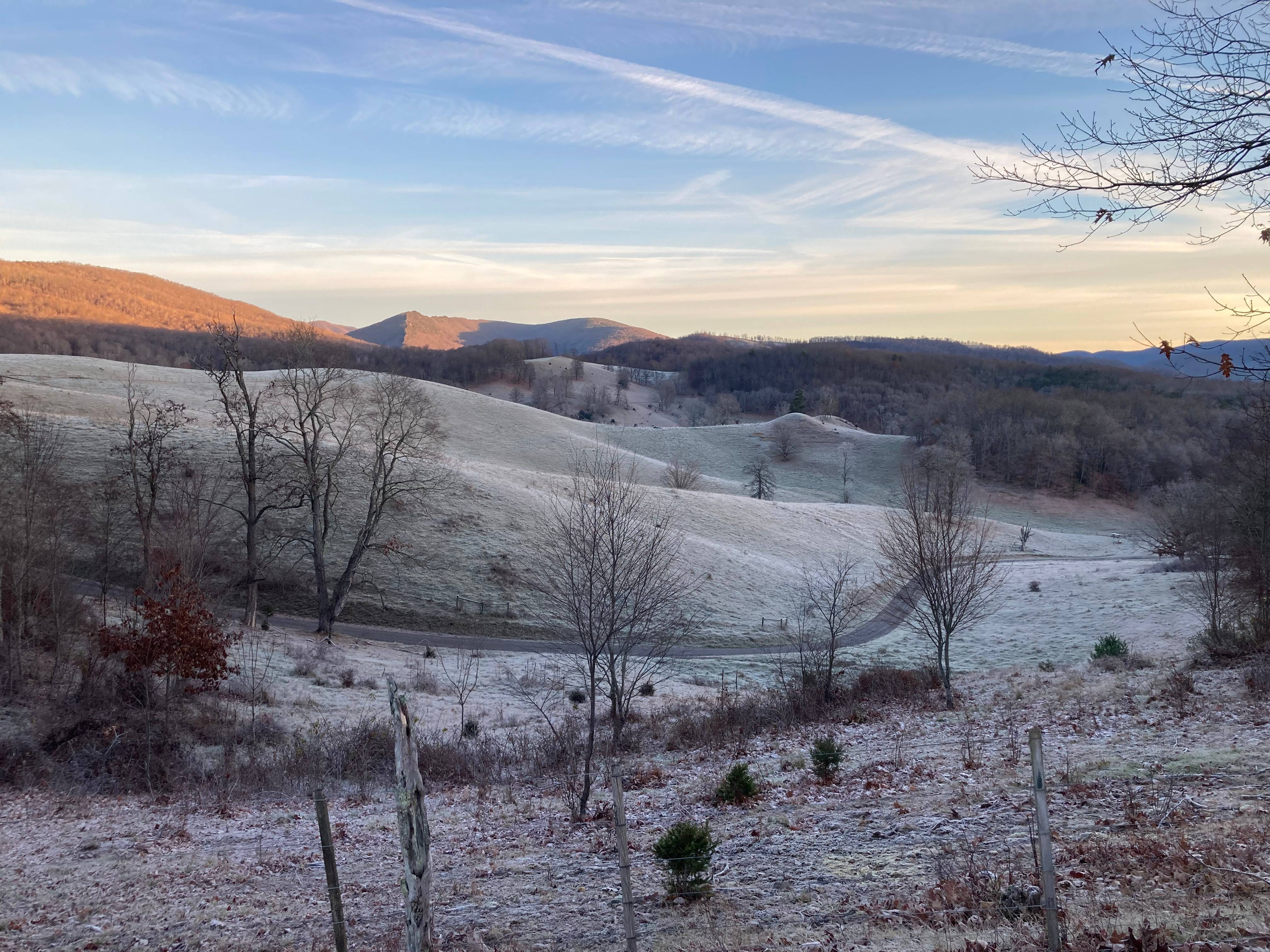 A few of the mountains, from the author's property. The trees are bare and the ground is covered in a thick layer of frost.