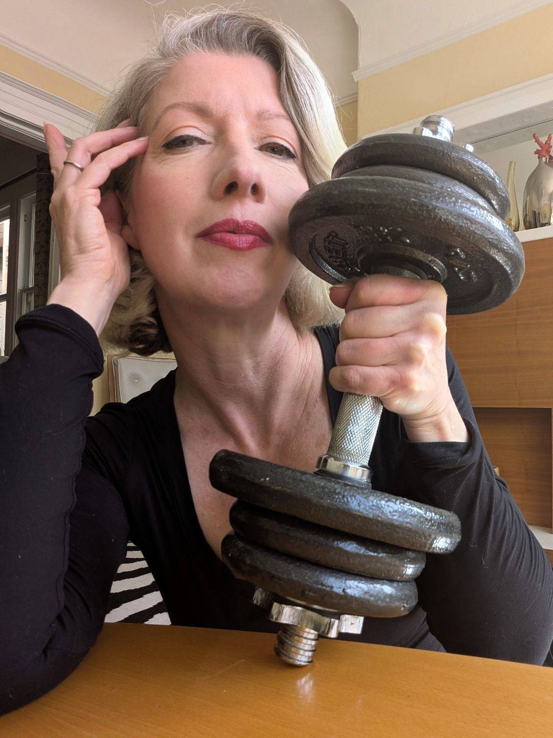 close up of middle aged woman holding loaded dumbbell