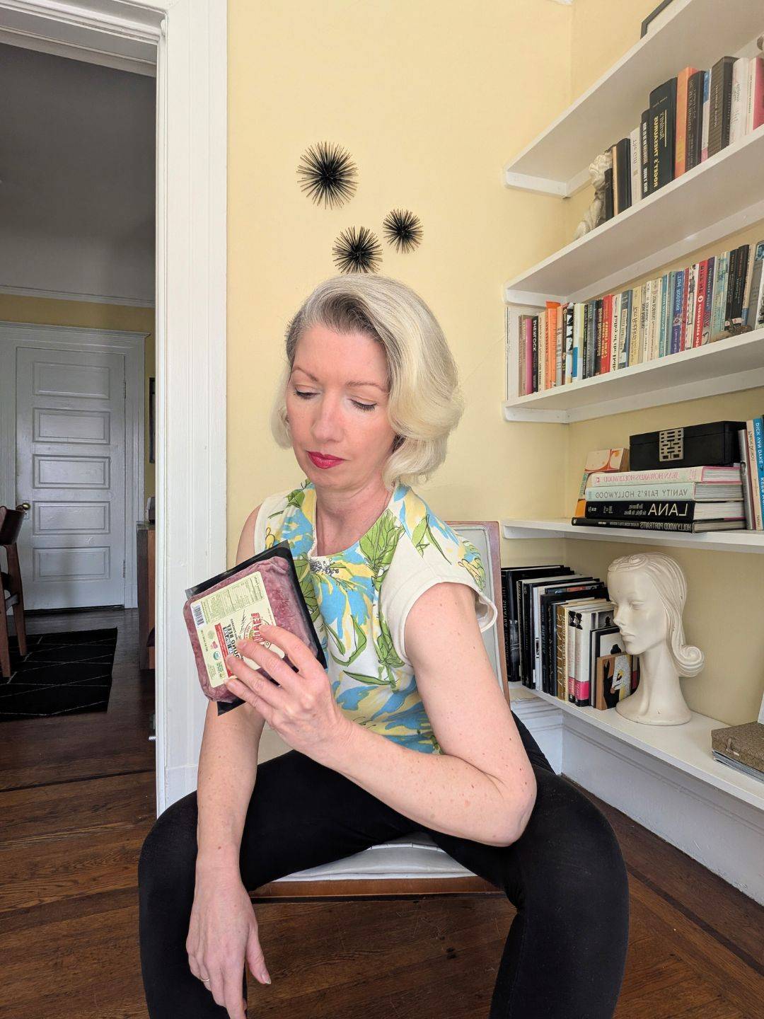 woman doing a bicep curl with a pound of packaged ground beef