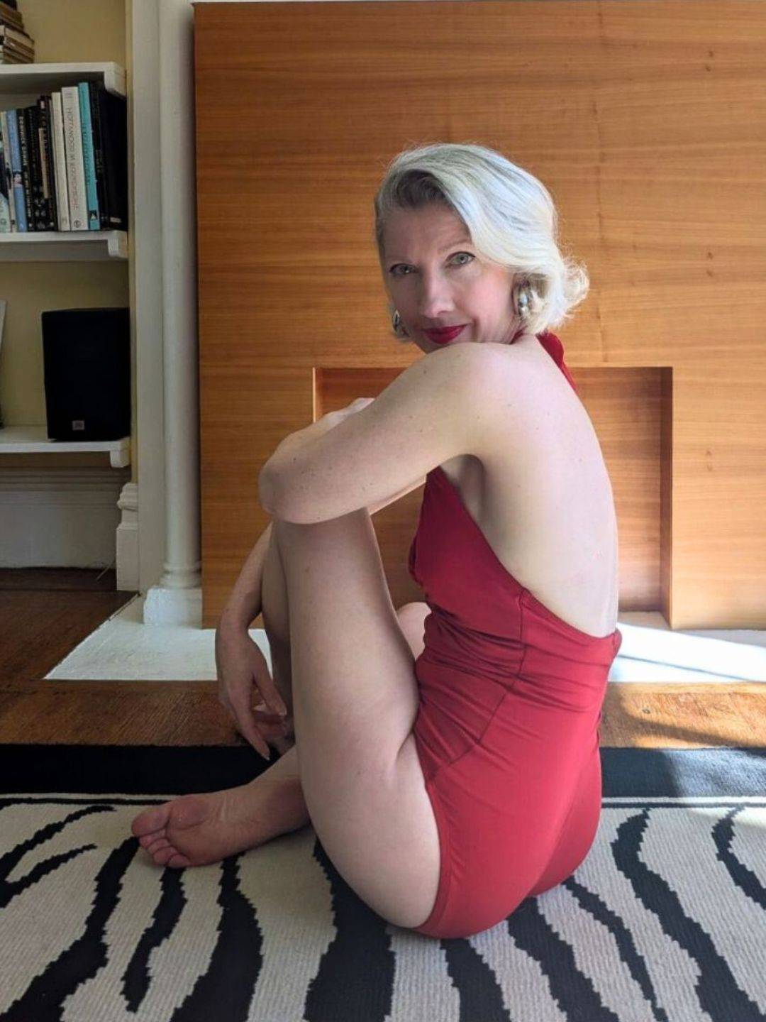 woman in red bathing suit sitting with back half facing camera