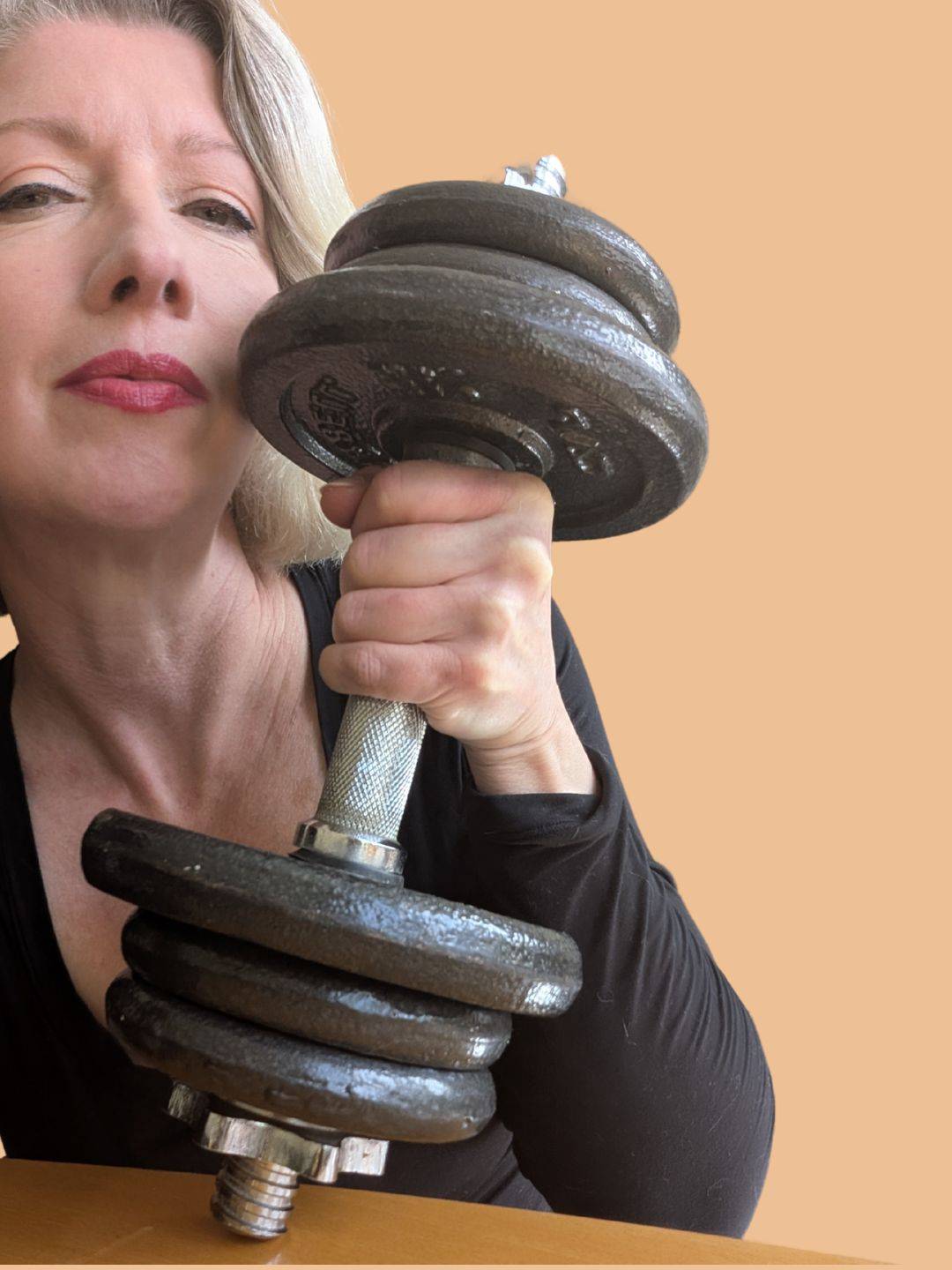 closeup pf woman's face, holding a heavy dumbbell