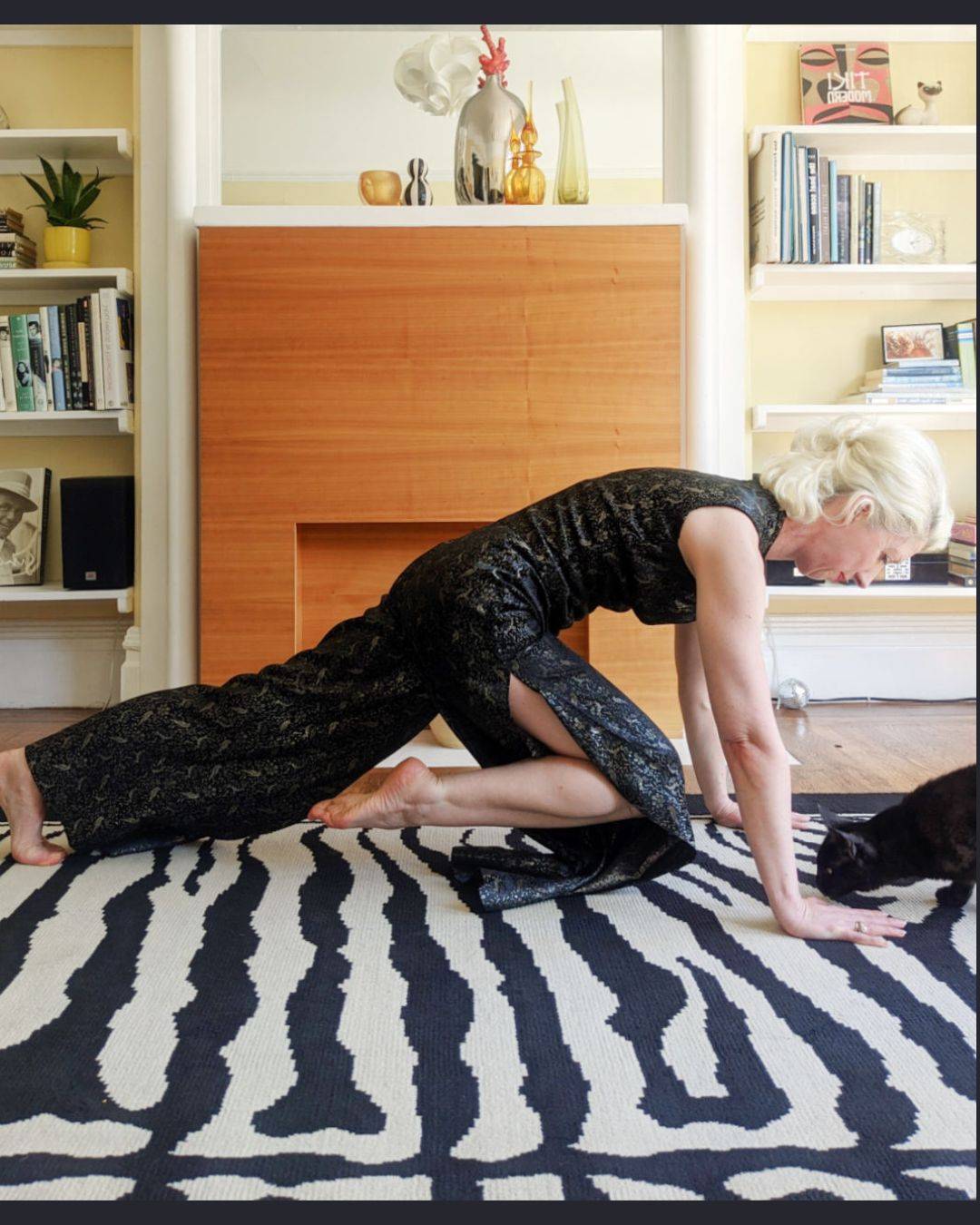 woman doing plank knee -in with black cat