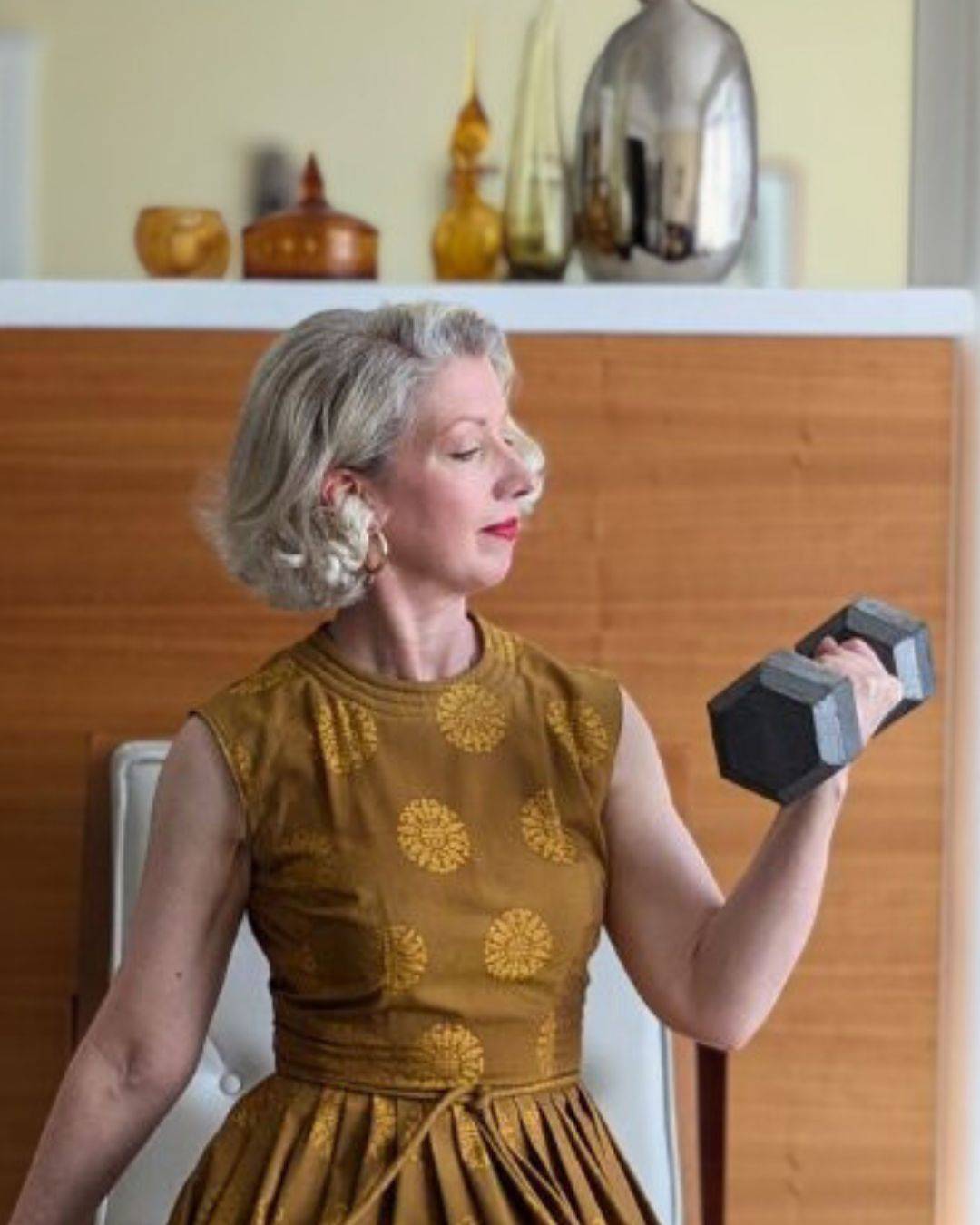 woman in gold cocktail dress doing a bicep curl