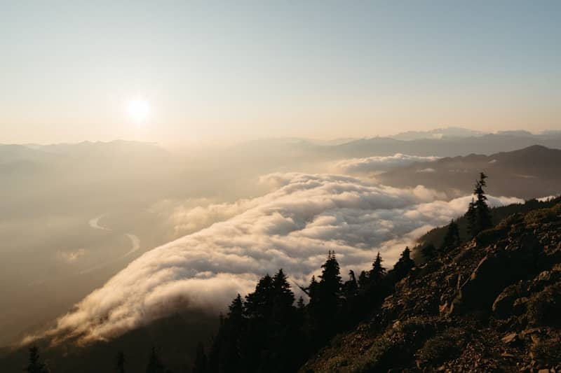 Mountains and clouds are illuminated by the setting sun.
