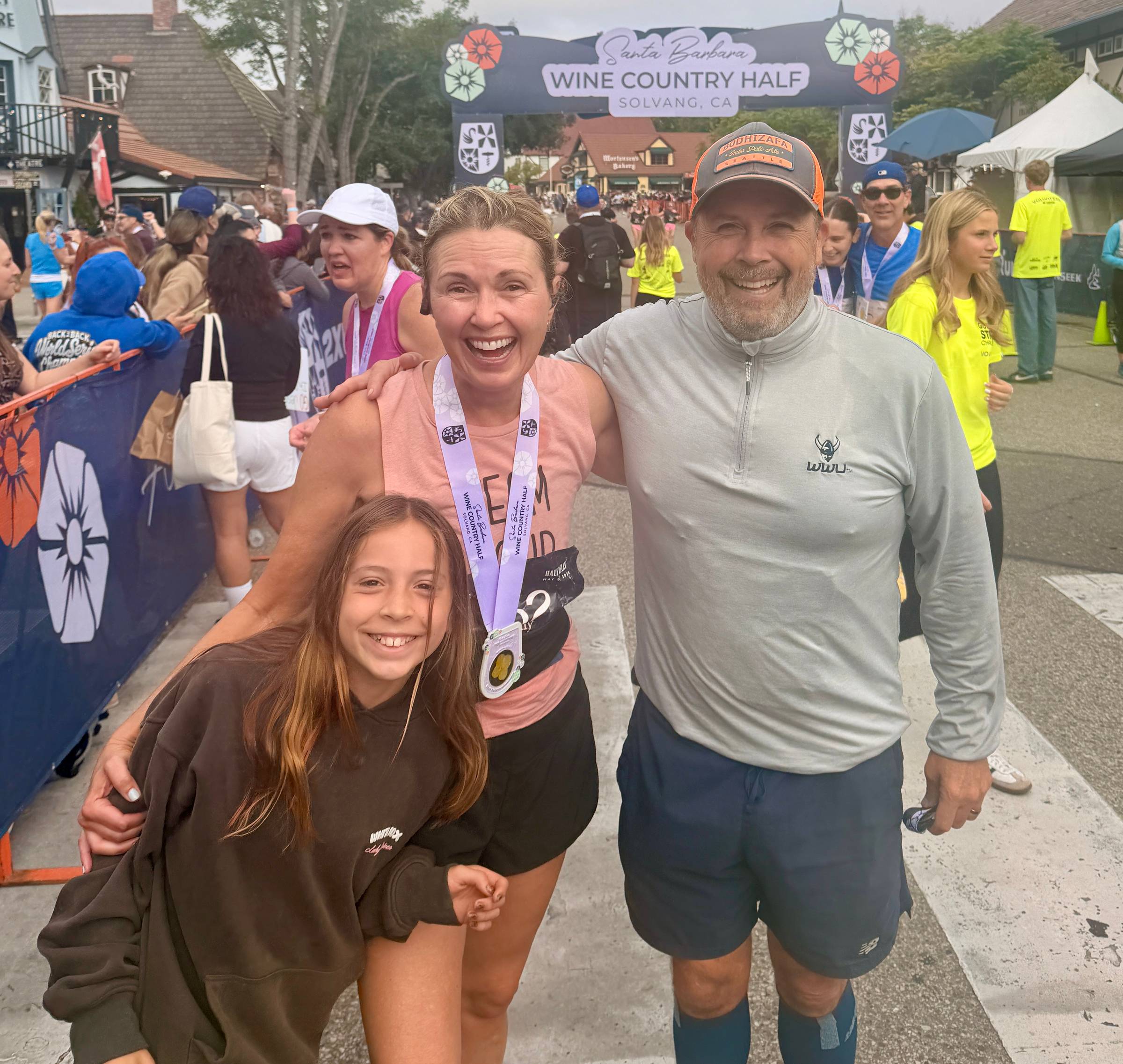 Tammy Messina with family at a race finish line, smiling and celebrating together.