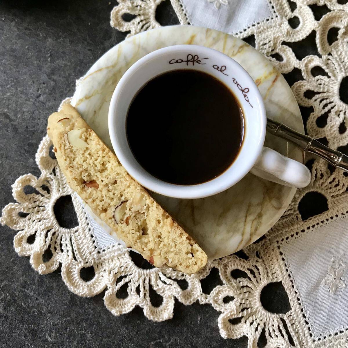 Almond biscotti next to a cup of espresso.