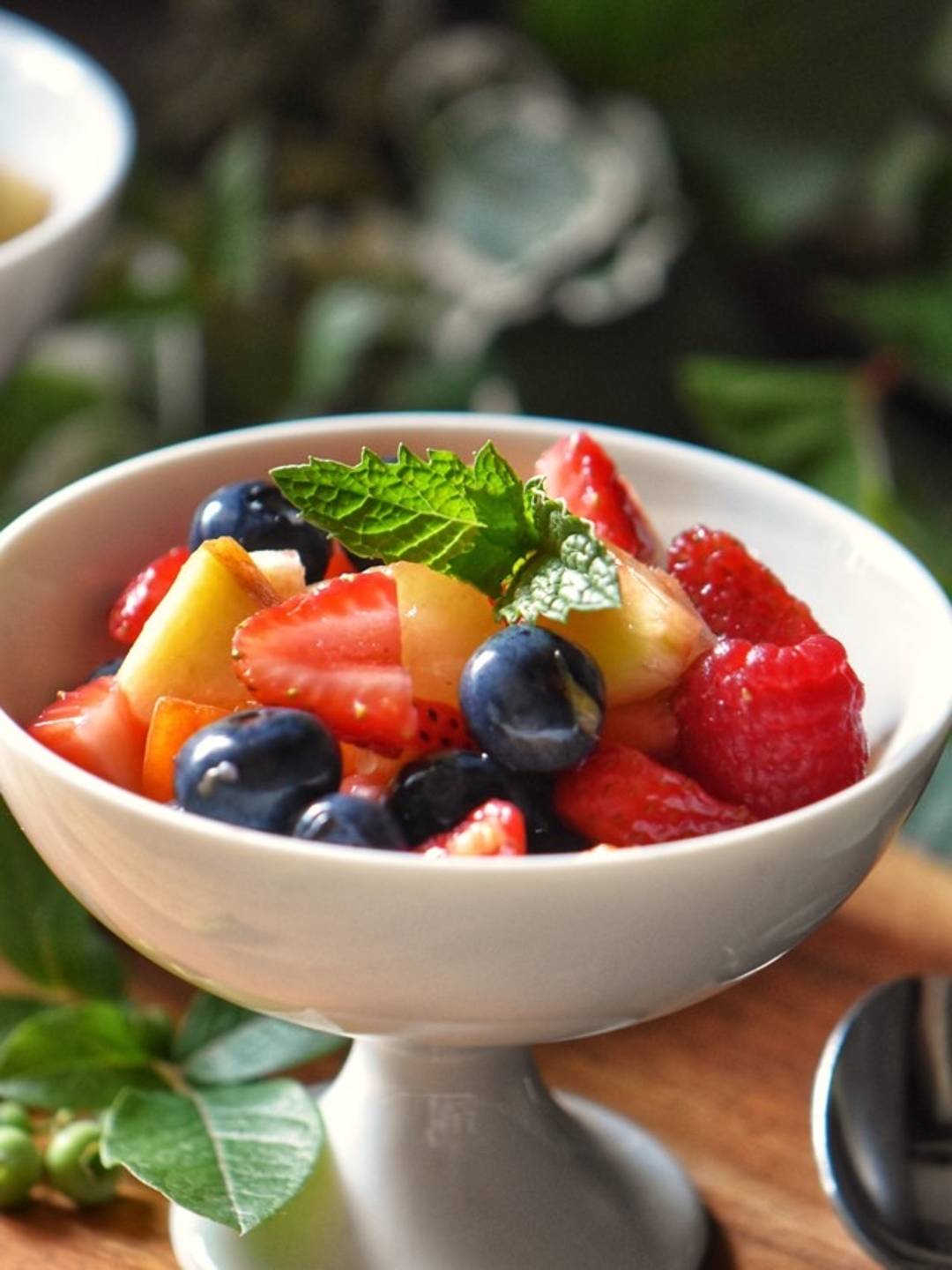 Fruit salad in a white dessert bowl.