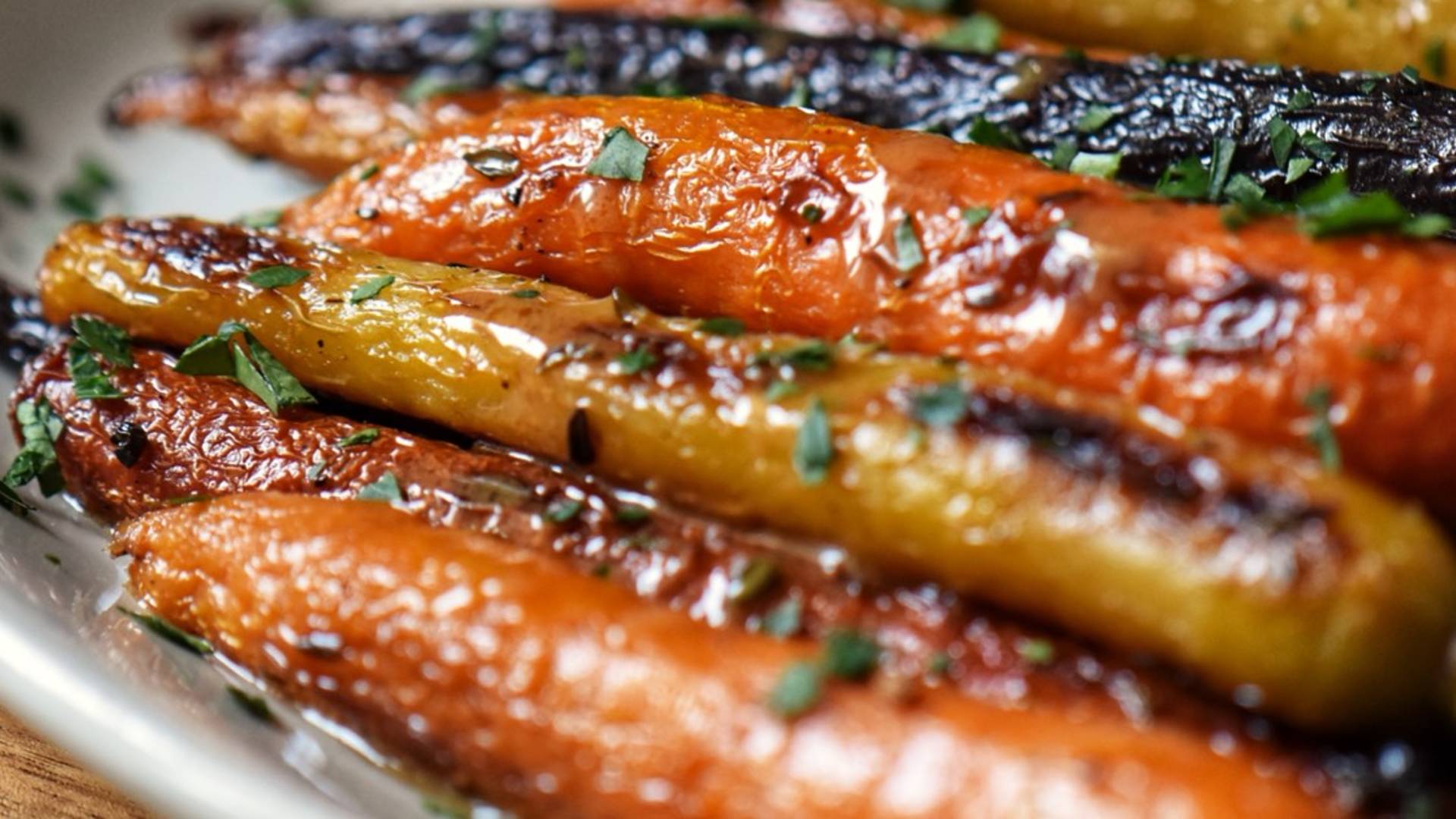 Colorful roasted rainbow carrots garnished with fresh parsley, ready to serve.