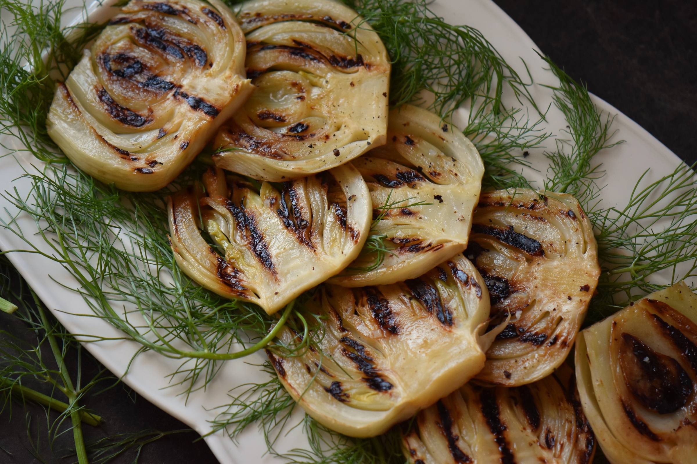 Grilled fennel on a white platter.