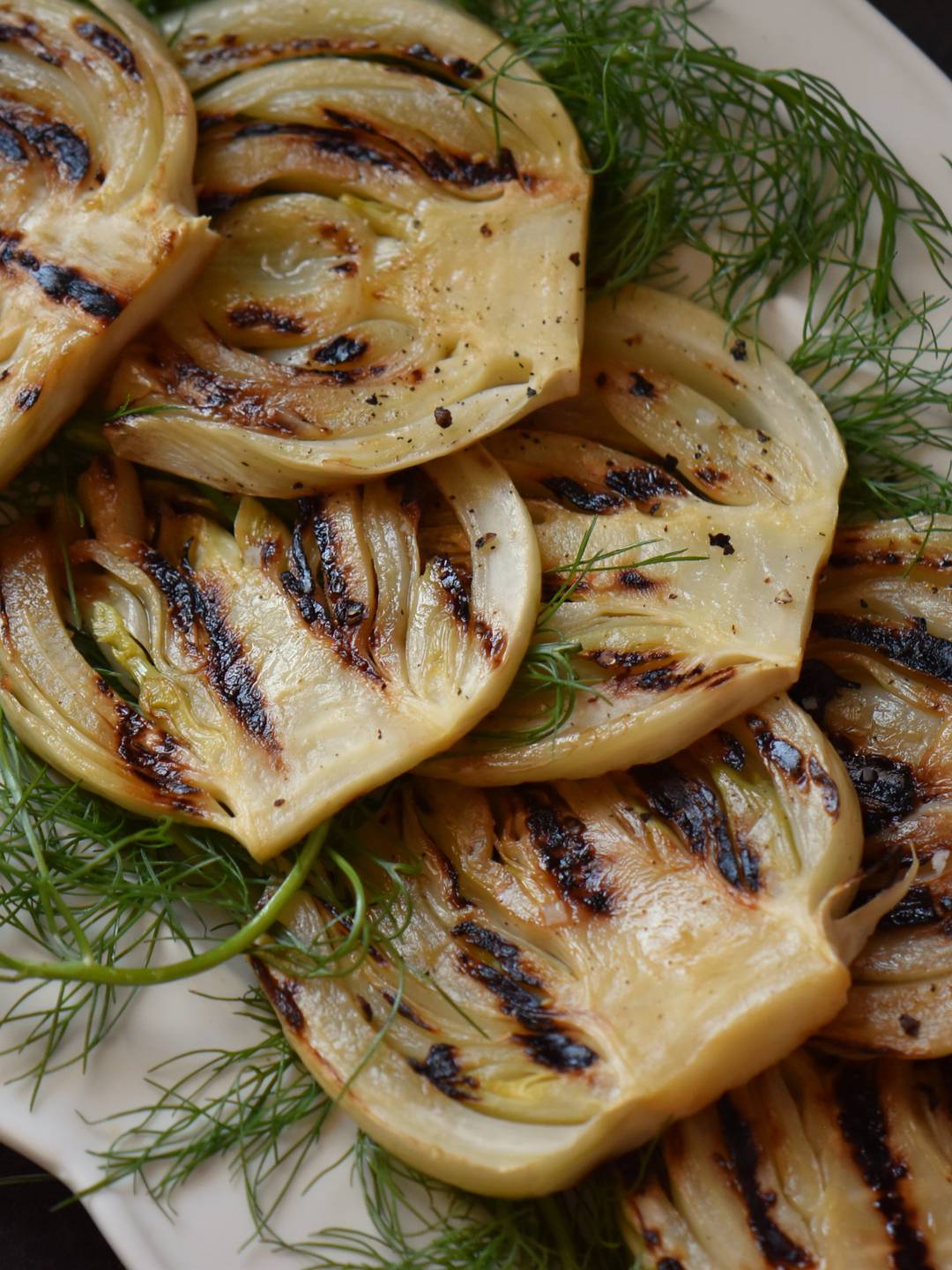Grilled fennel on a white platter.
