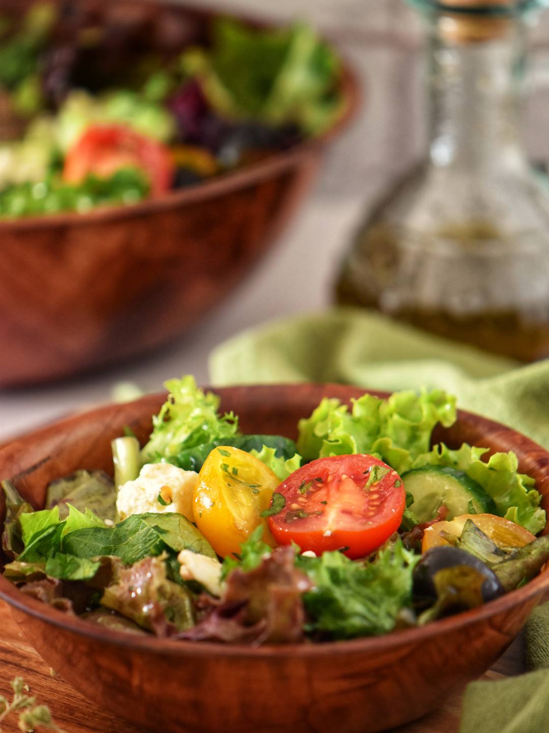 Mixed salad greens in a wooden bowl.