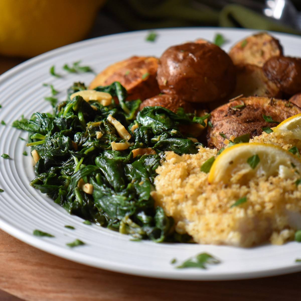 Sauteed spinach with garlic on a white dinner plate.
