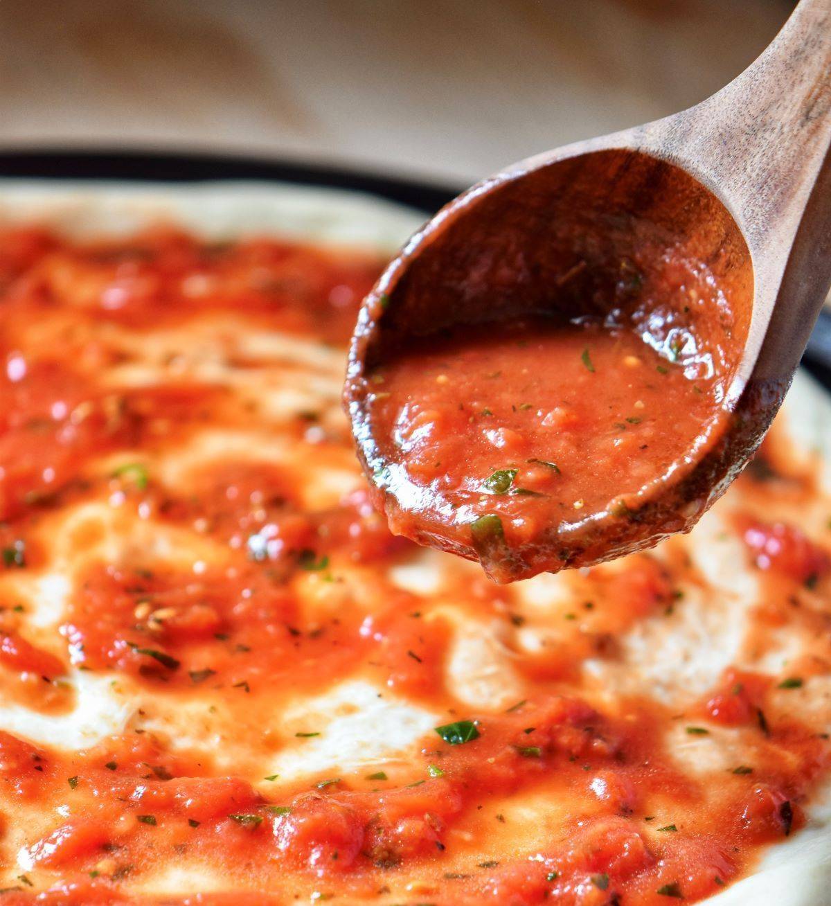 A ladle of pizza sauce.