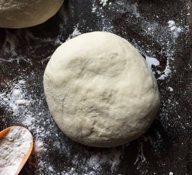 Pizza on a floured surface.