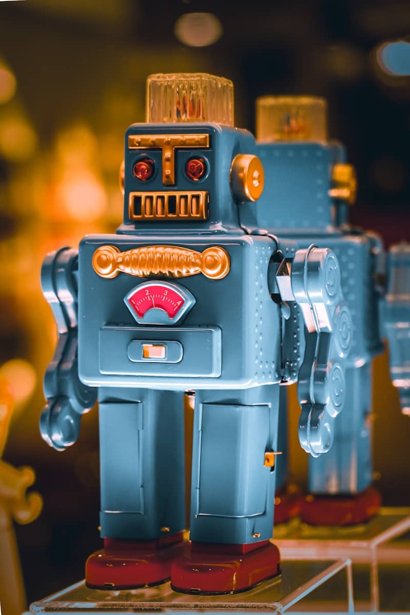 Two vintage tin robots standing side by side.
