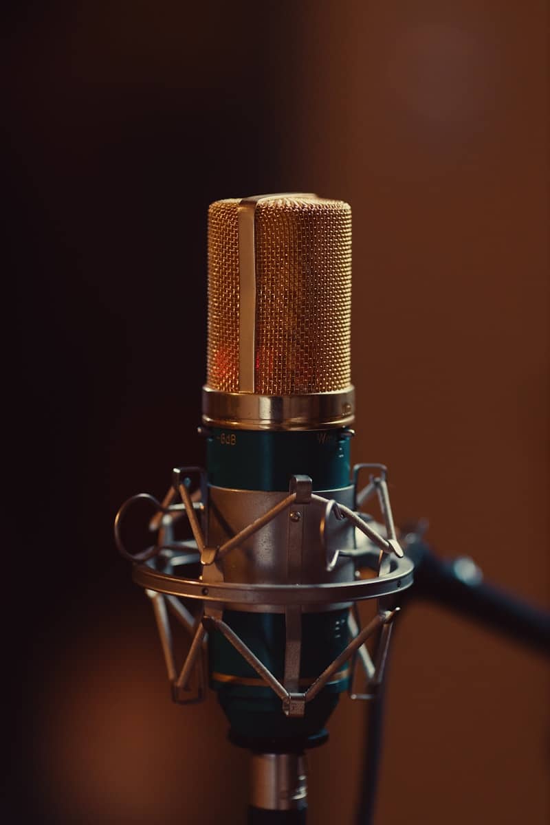 A vintage gold condenser microphone in a recording studio.