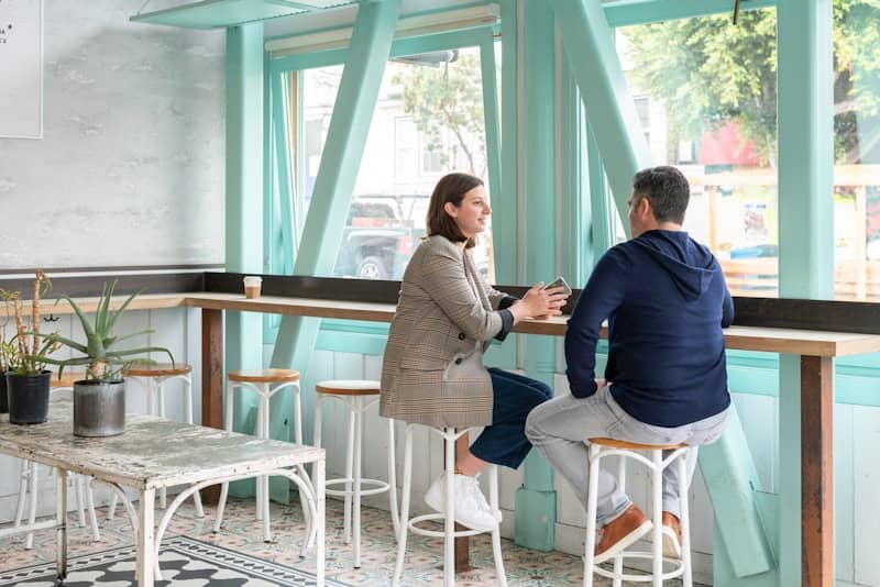 man and woman sitting on white chair